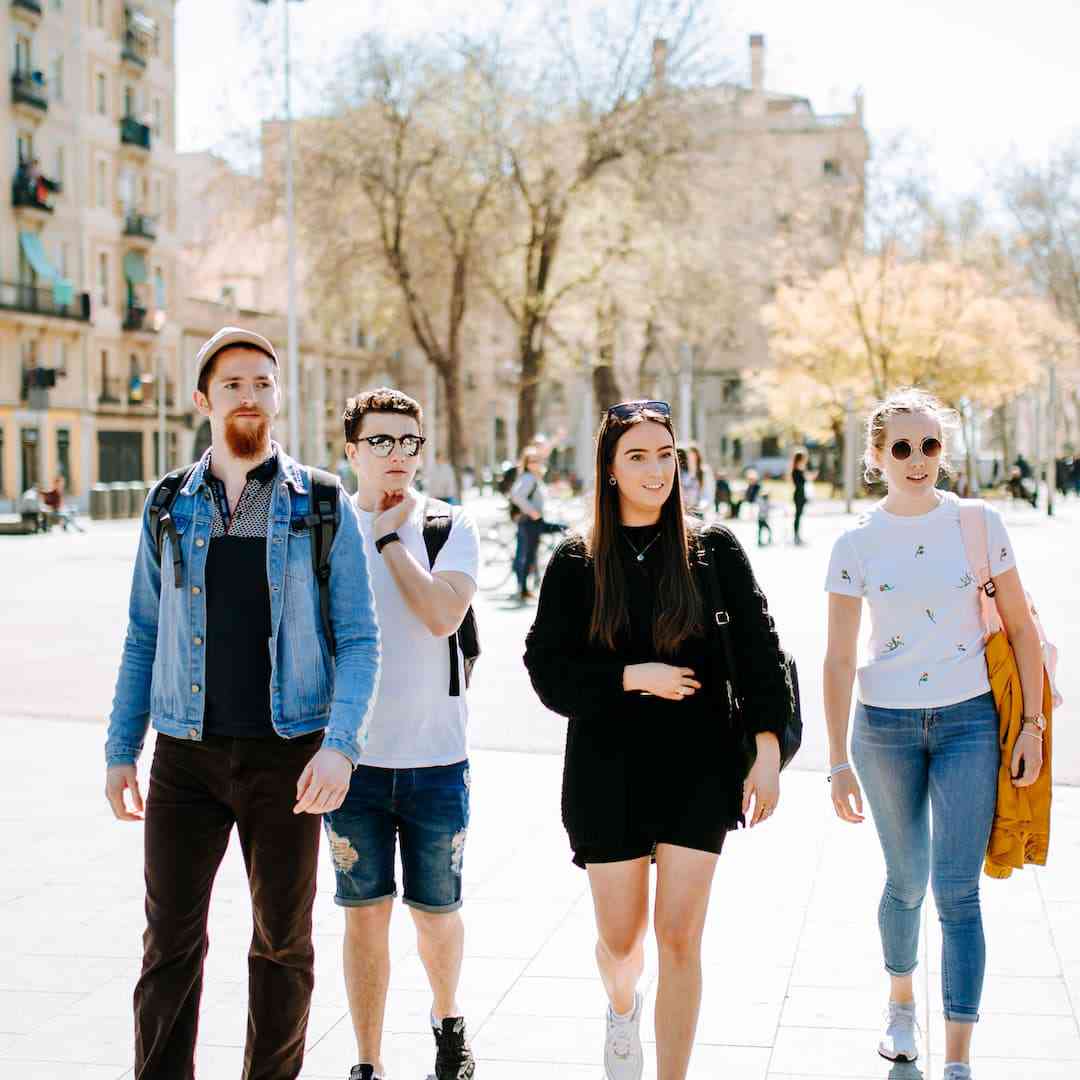Five Geography students walking the streets of Barcelona. They're turning to look at something in the near distance.