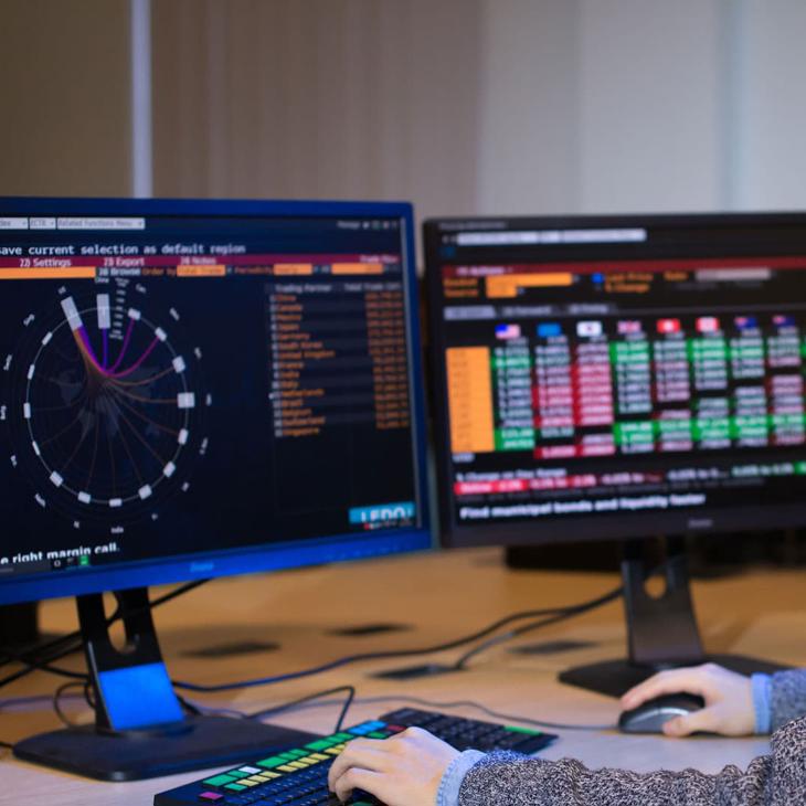 Accounting and Financial Management student, Yujia Ding, using trading software on a computer in the Bloomberg Suite.