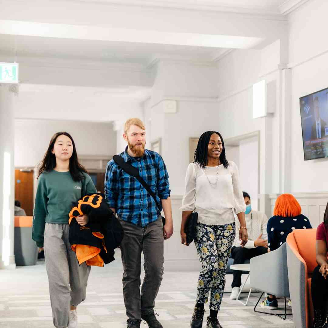 Students walking in the bright, modern surroundings of the Executive Education Suite at Hull University Business School.