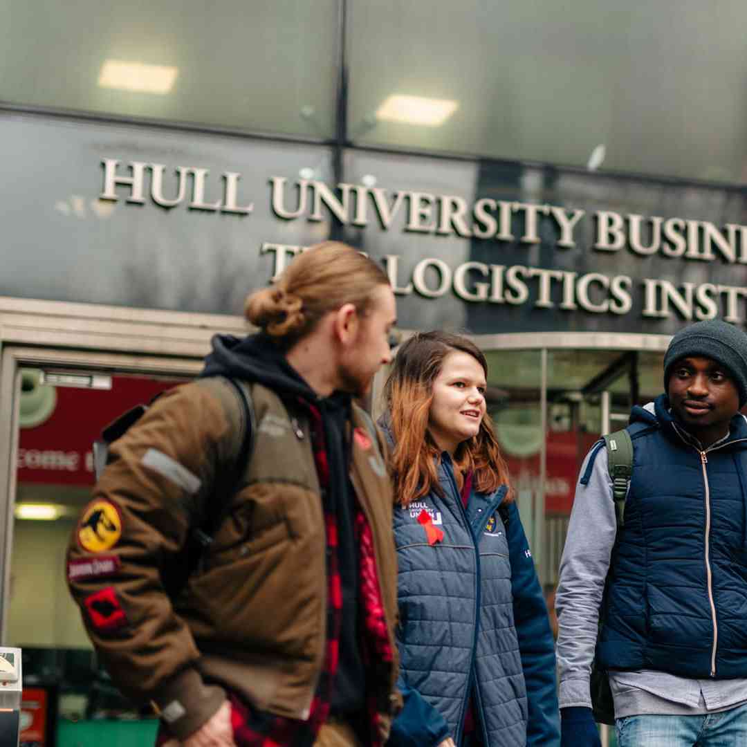 Three Business students walking out of the University's Nidd building