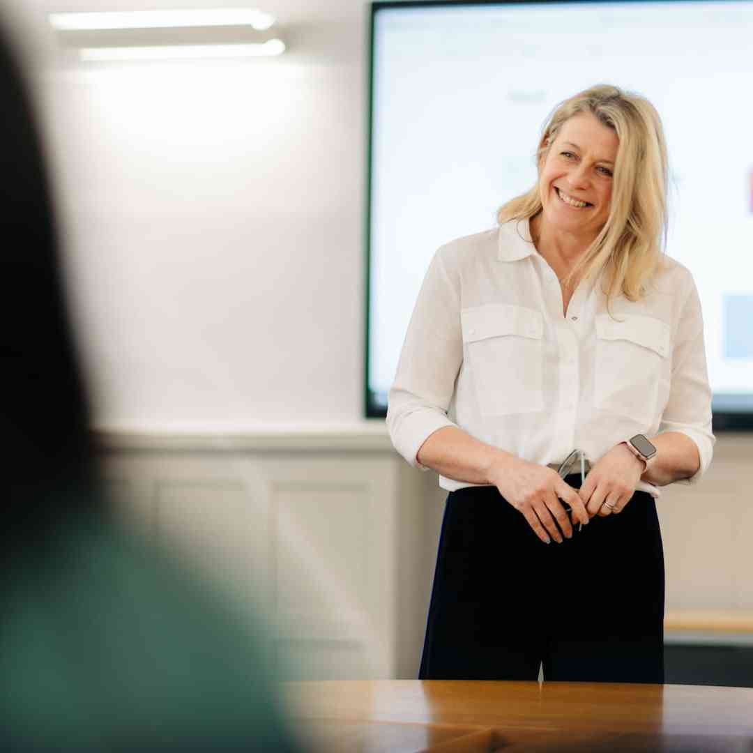 A lecturer smiling while hosting a seminar in the Business School