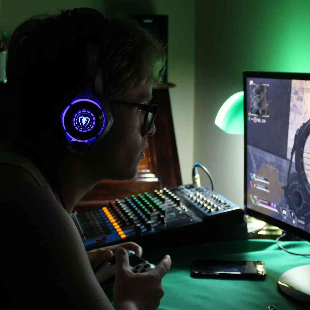  A student wearing headphones plays a first person PC game