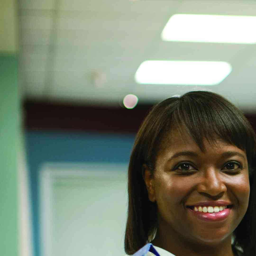 a smiling nurse at a hospital reception desk