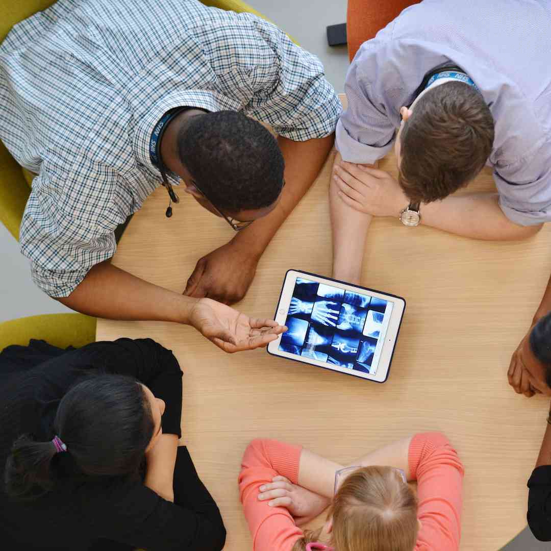 Aerial image of a group of students viewing X ray images on a tablet computer