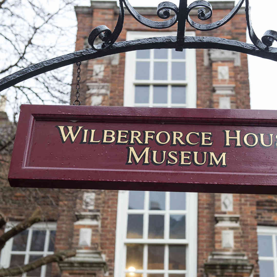 The Wilberforce House Museum sign, red with gold lettering, above the entrance to the house: a Grade I listed building.