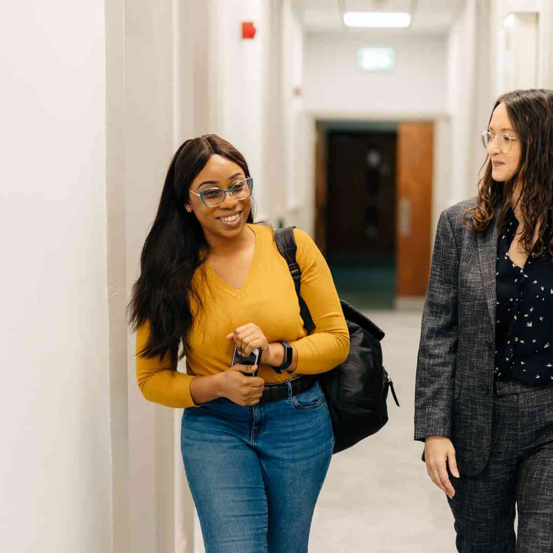 Two students walking through the Legal Advice Centre corridor