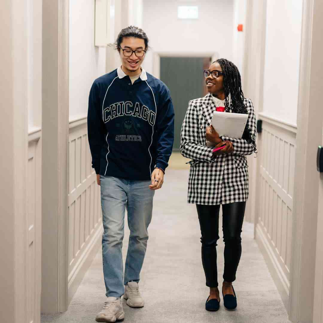 Two students walking down the Legal Advice Centre corridor carrying paperwork