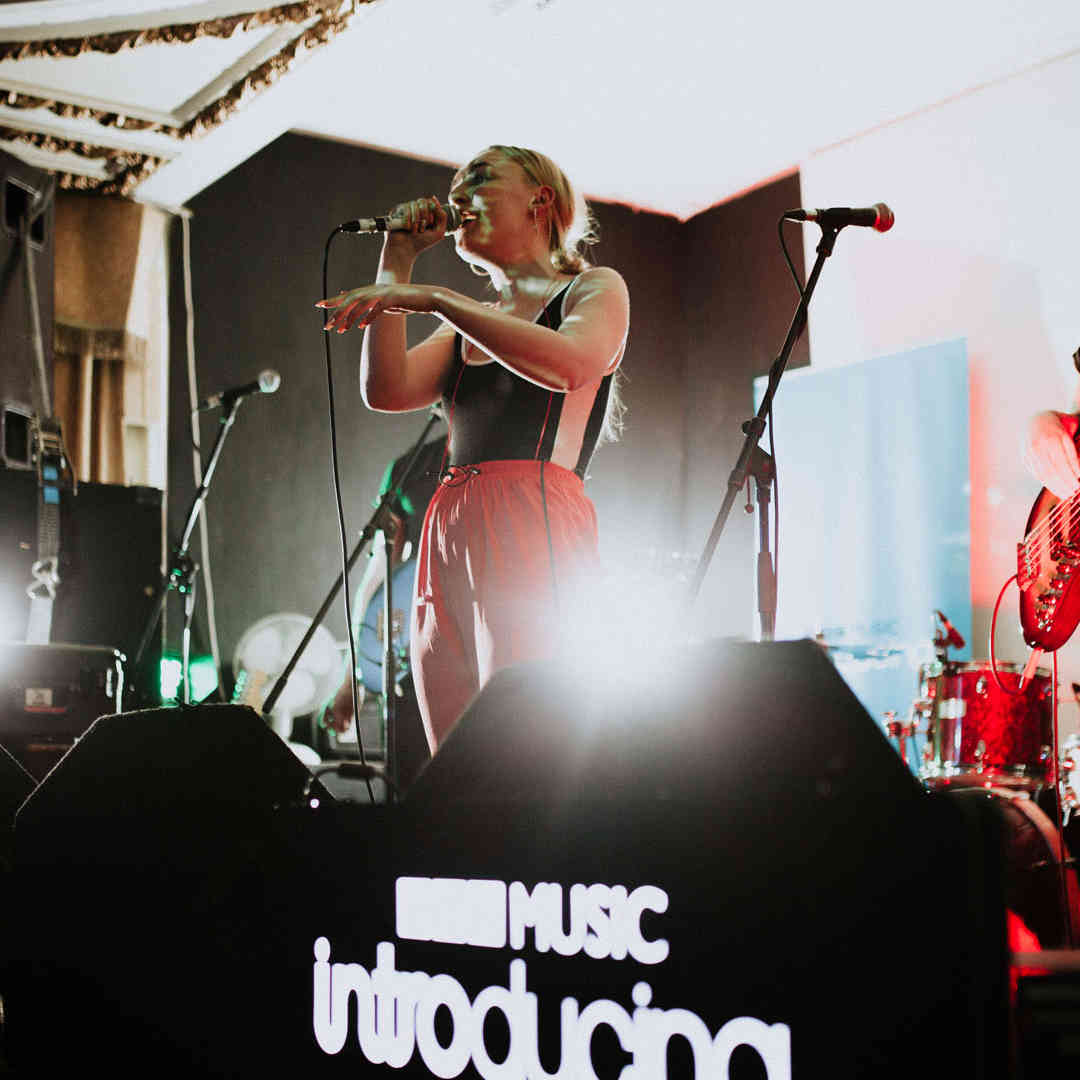 Hull Music student band, including singer, bass player and drummer, performing on a BBC Music Introducing stage.