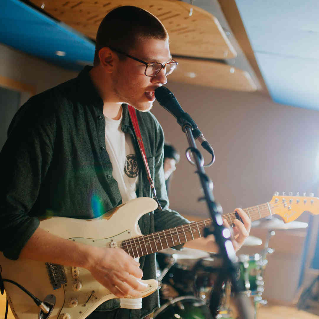 Music student, Max Lilley, playing electric guitar in one of Hull's professional recording studios.
