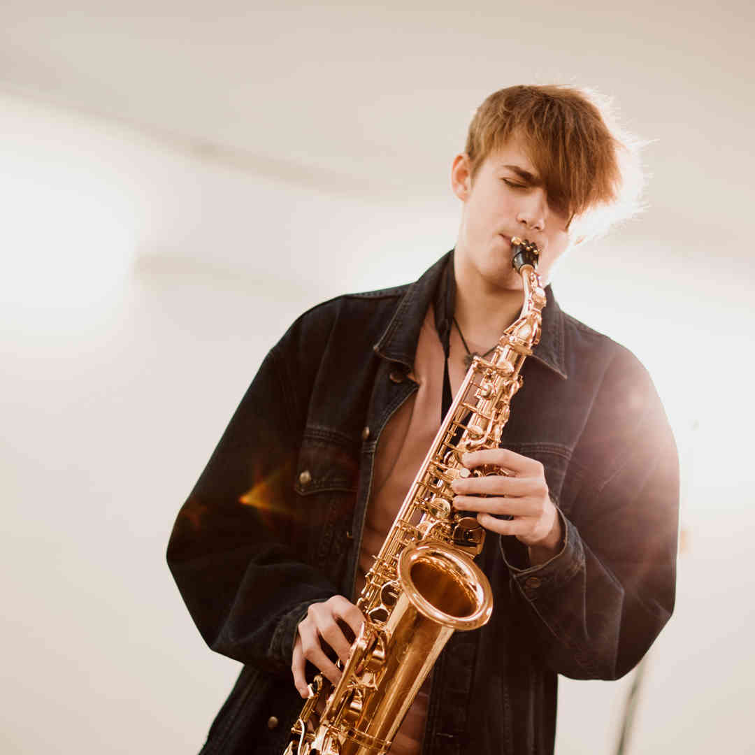 Hull Music student, James Curgenven, stands playing the saxophone.