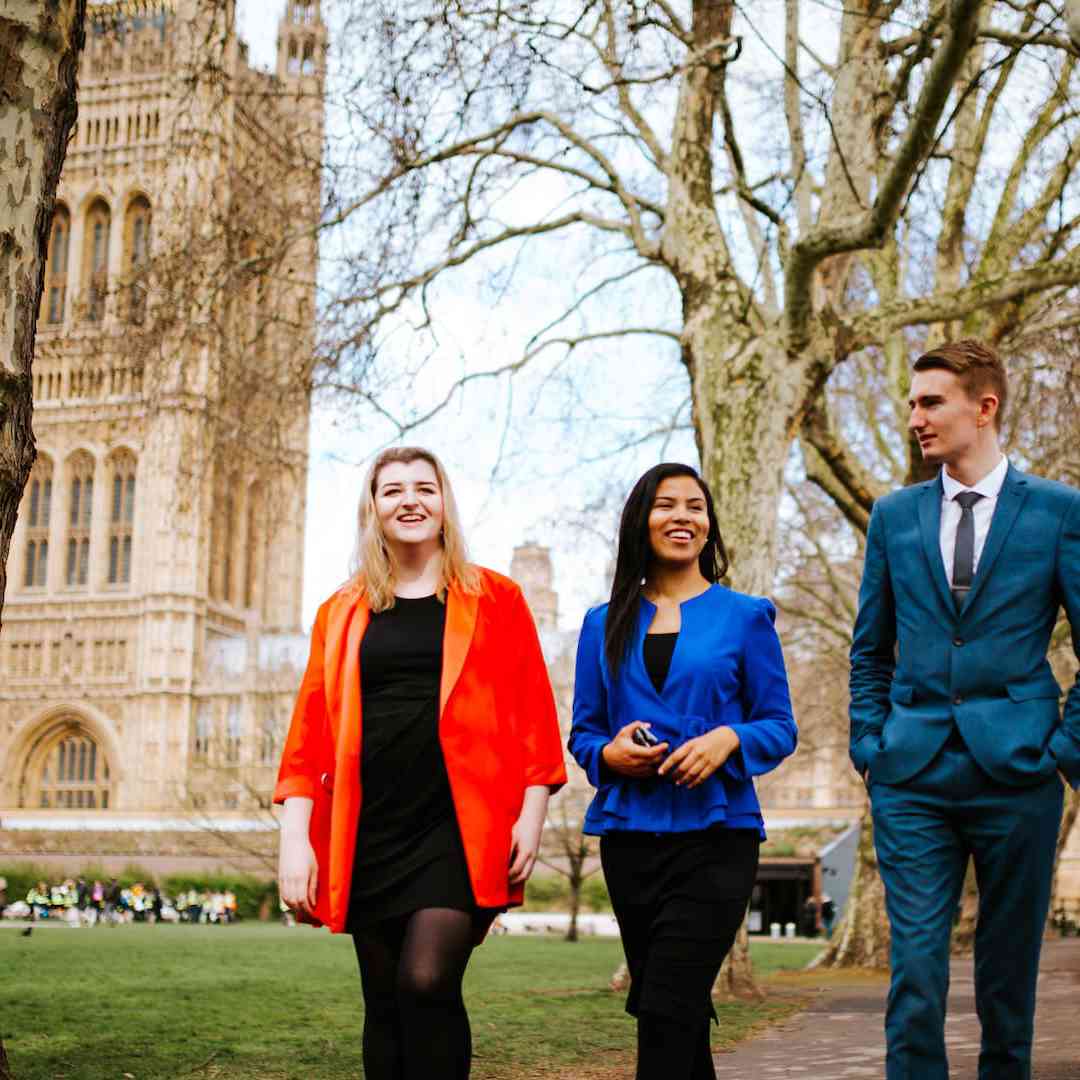 Three smartly dressed politics students walking through the grounds of Westminster