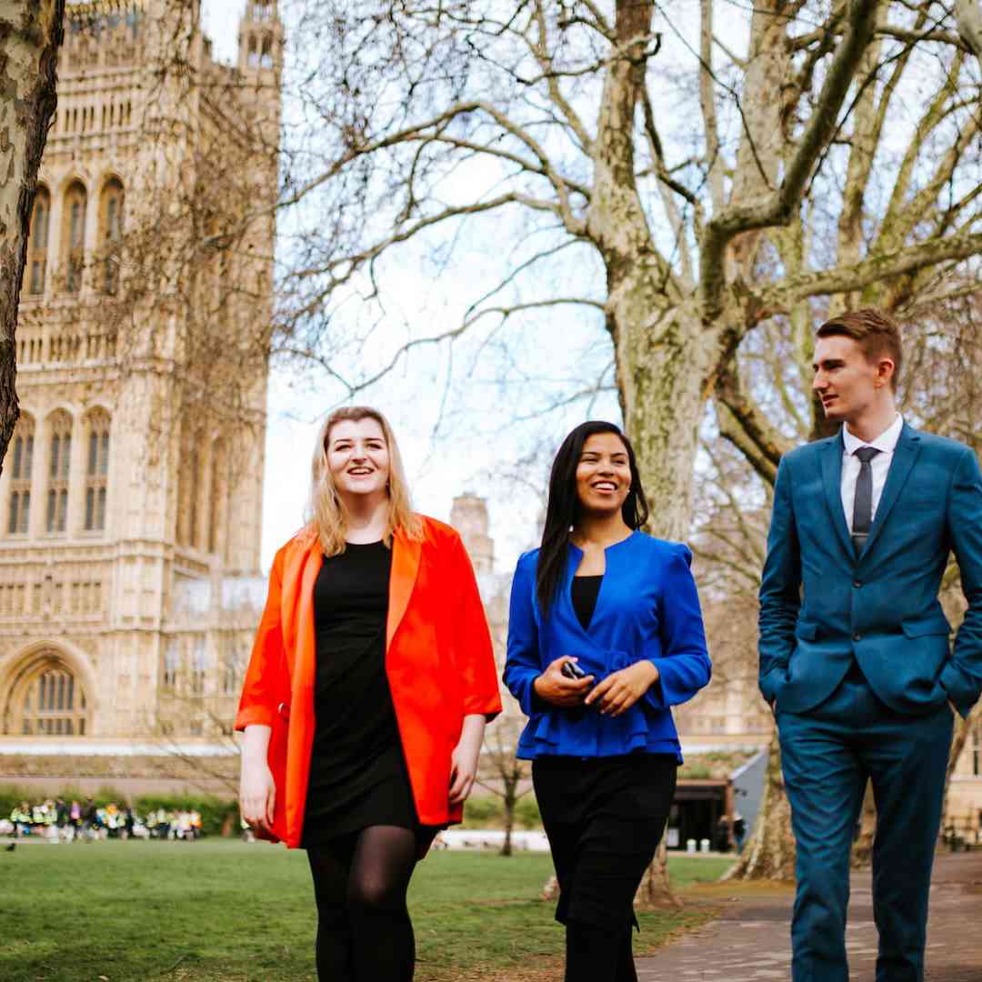 Three of our politics students walking and chatting outside the Houses of Parliament.
