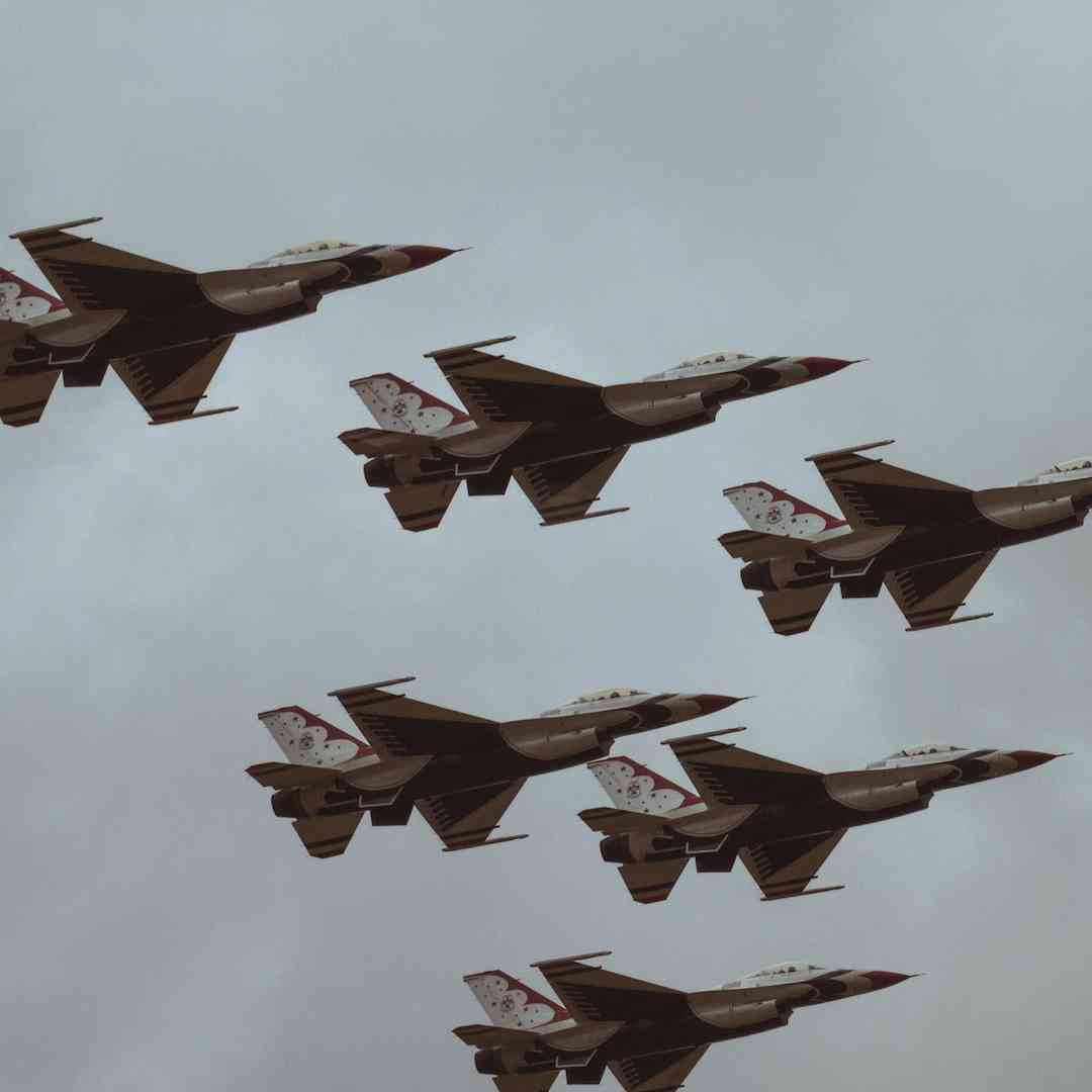 Six F16s flying through a cloudy sky.