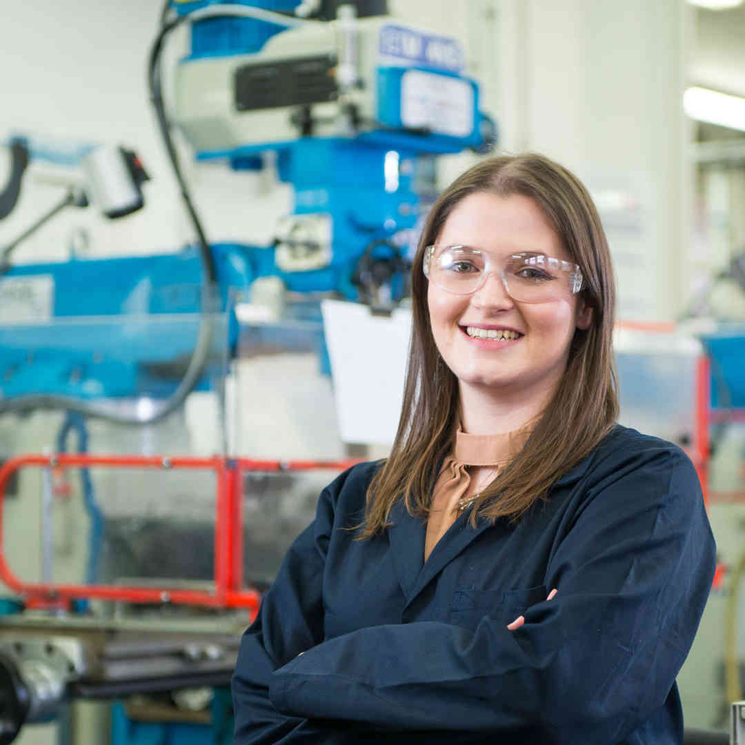 Hull student, Charlotte Urwin, in goggles and overalls in the mechanical engineering workshop.