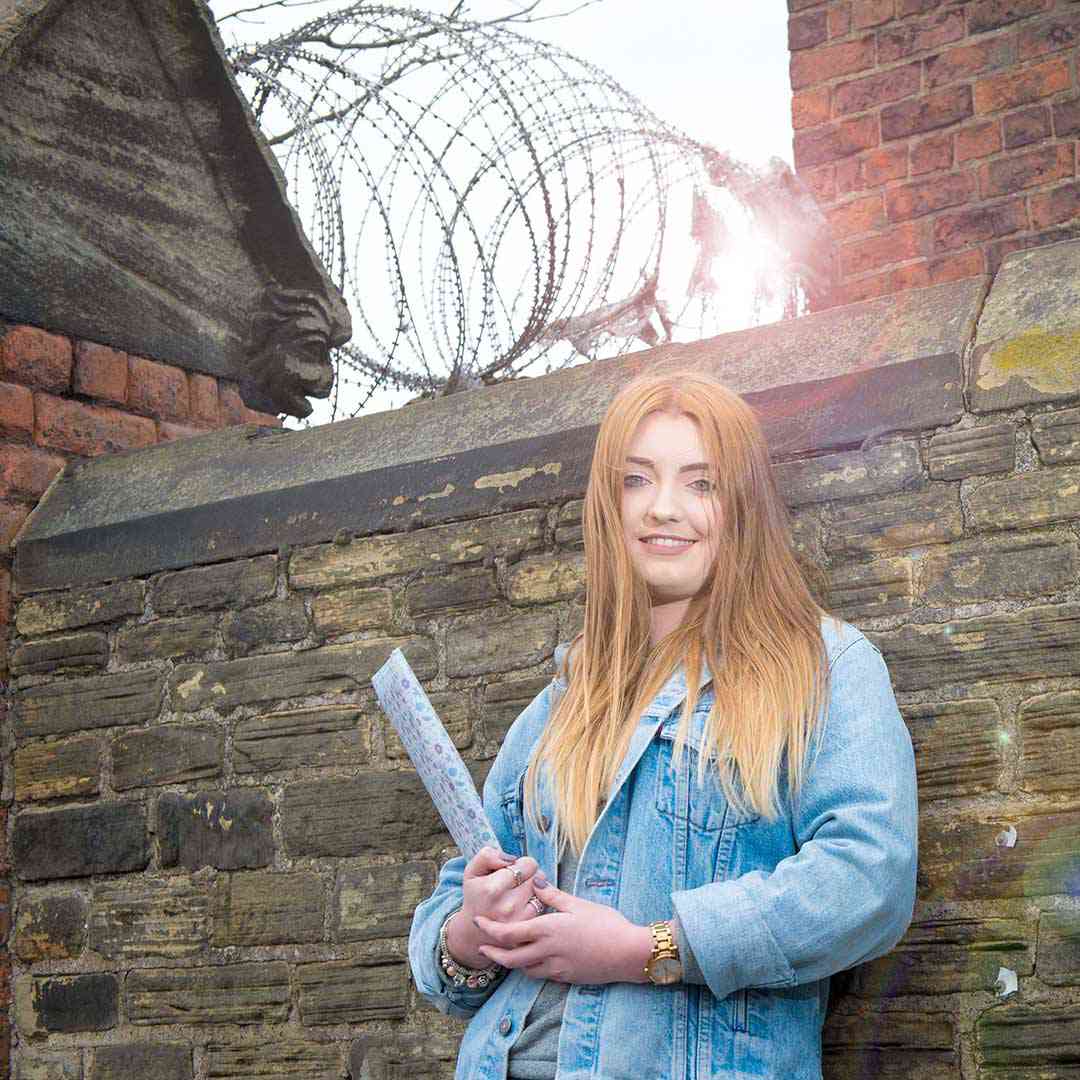 A Criminology student leaning against a wall outside Hull Prison