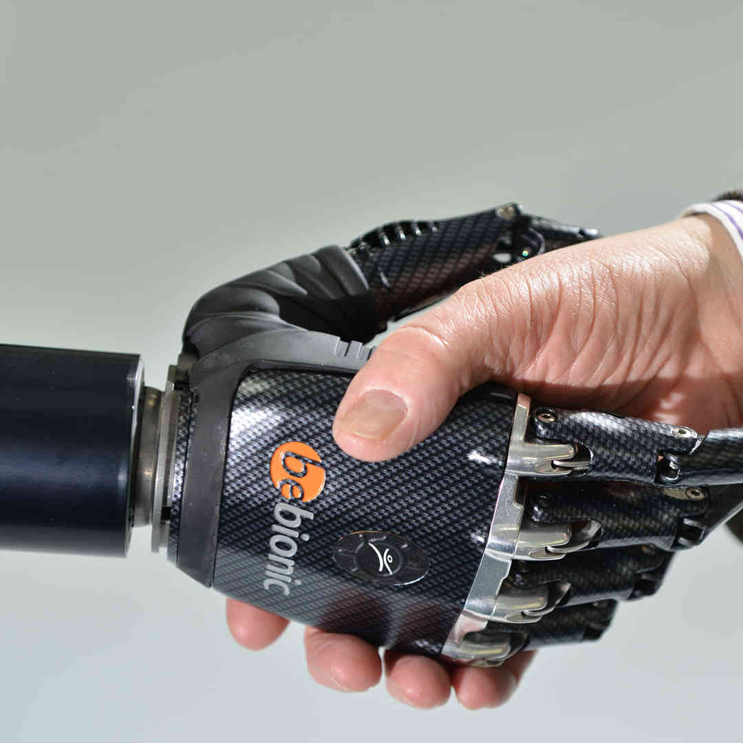 A lecturer shaking hands with a robotic hand