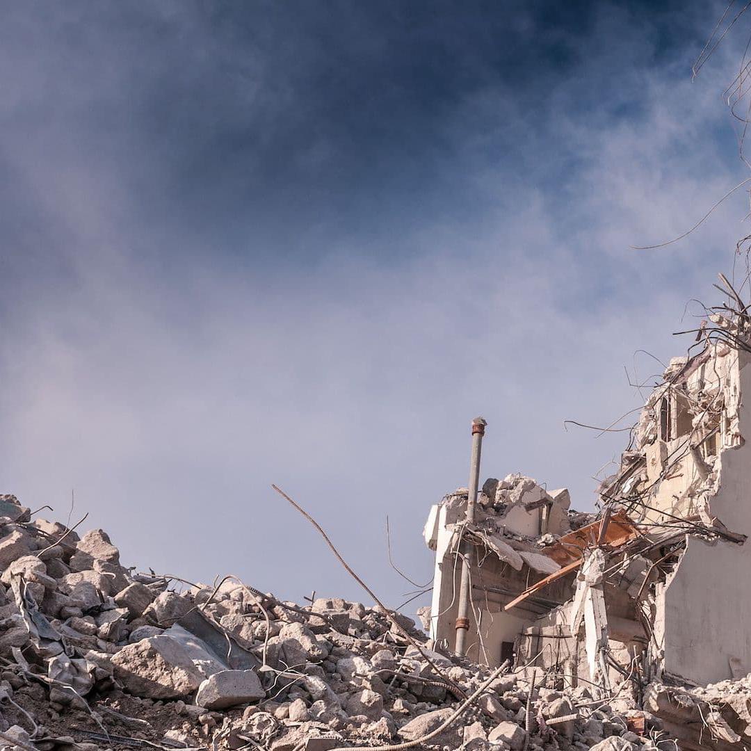 A demolished building is left only half standing with rubble strewn all over the floor