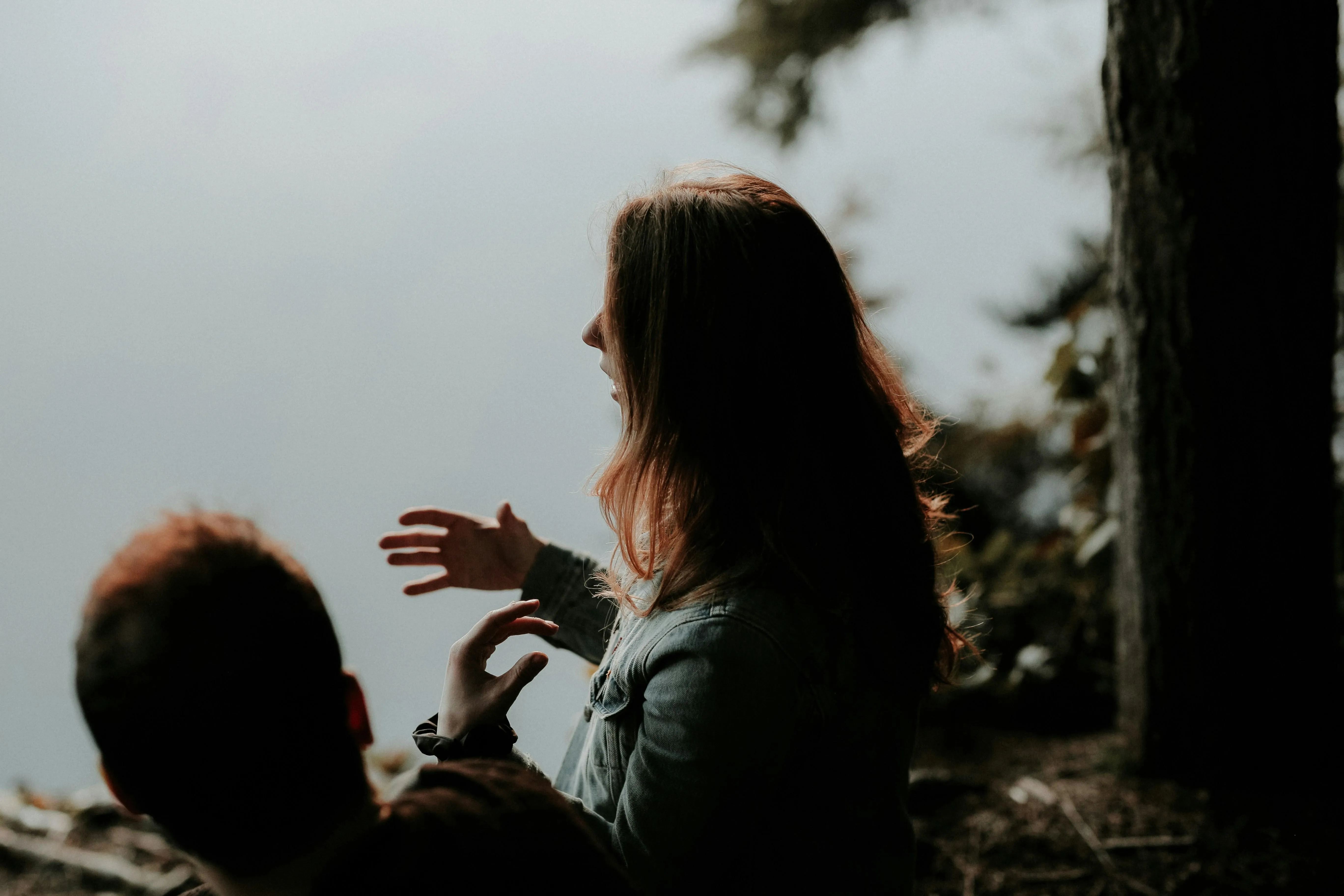 A young women talking to man in a forest