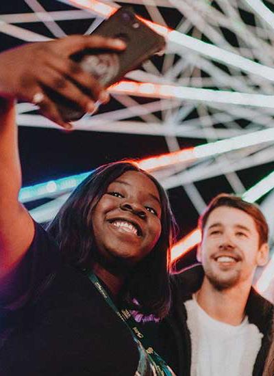 A group of three friends stop for a selfie in front of the big wheel at Hull Fair.