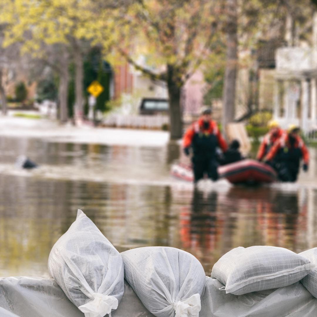 A group of rescuers using an inflatable raft rescue victims of flooding