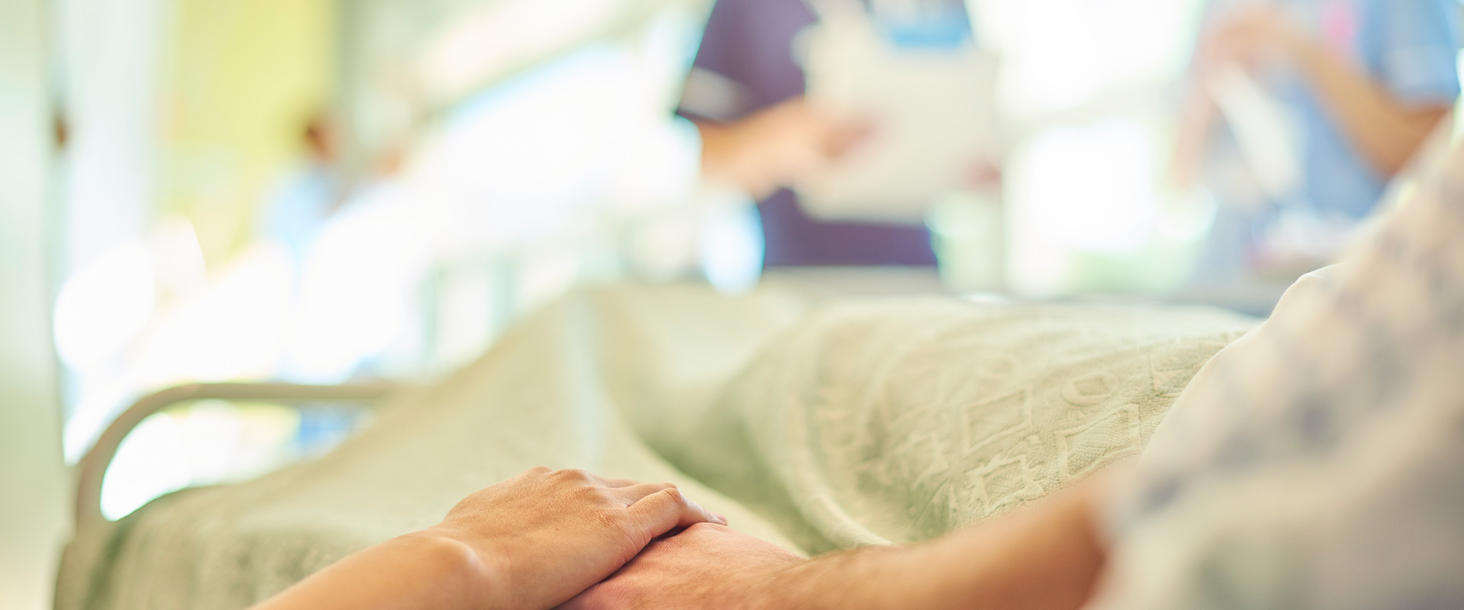 Hospital-Bed-Holding-Hands-iStock-619266666