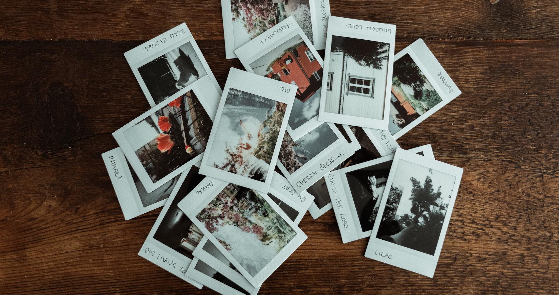 A selection of polaroids on a wooden table