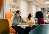 Two students sit around a table in the Business Lounge