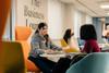 Two female students sat around a table in the Business Lounge