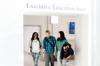 Three students walking out of the Executive Education Suite