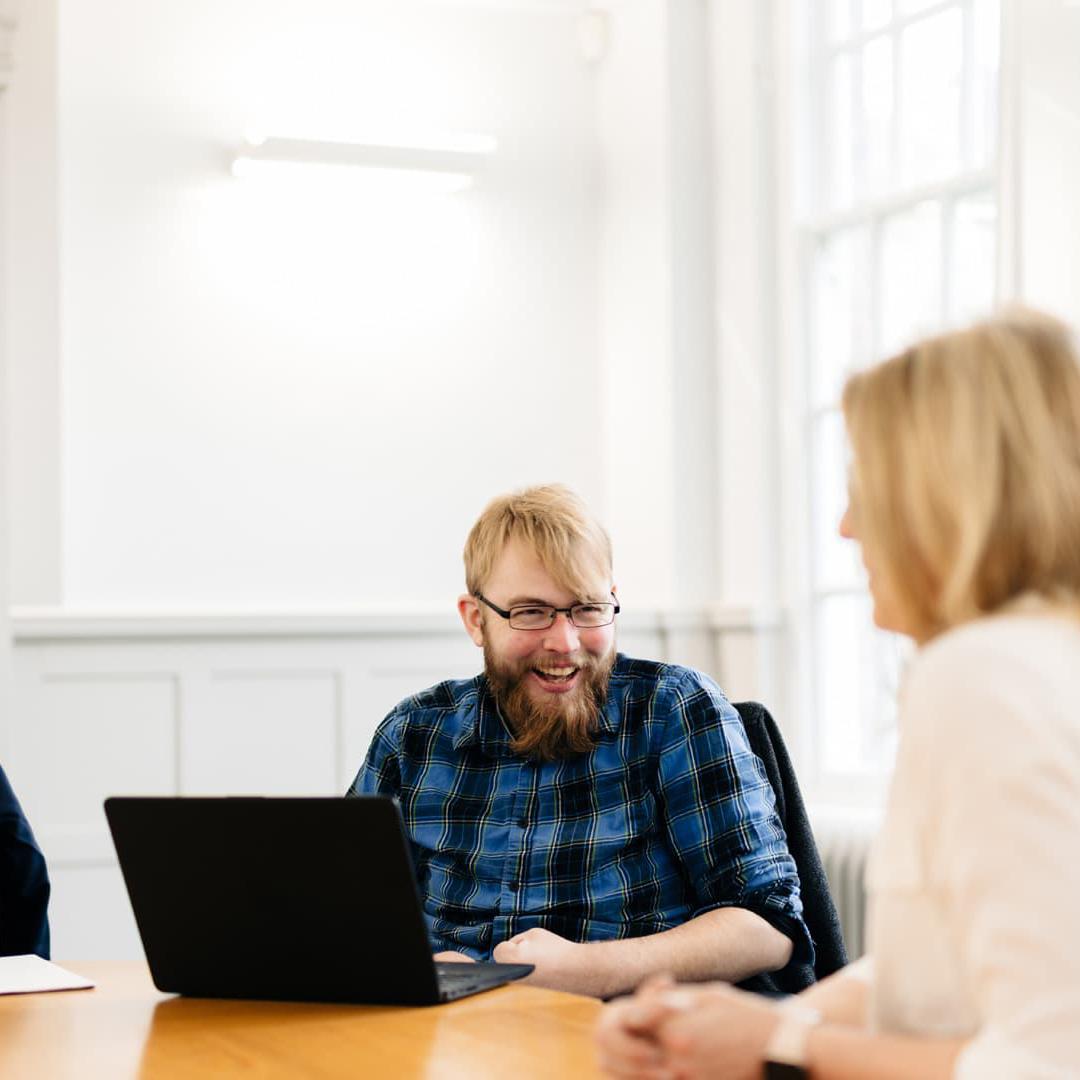 A lecturer and a student talking around a table 