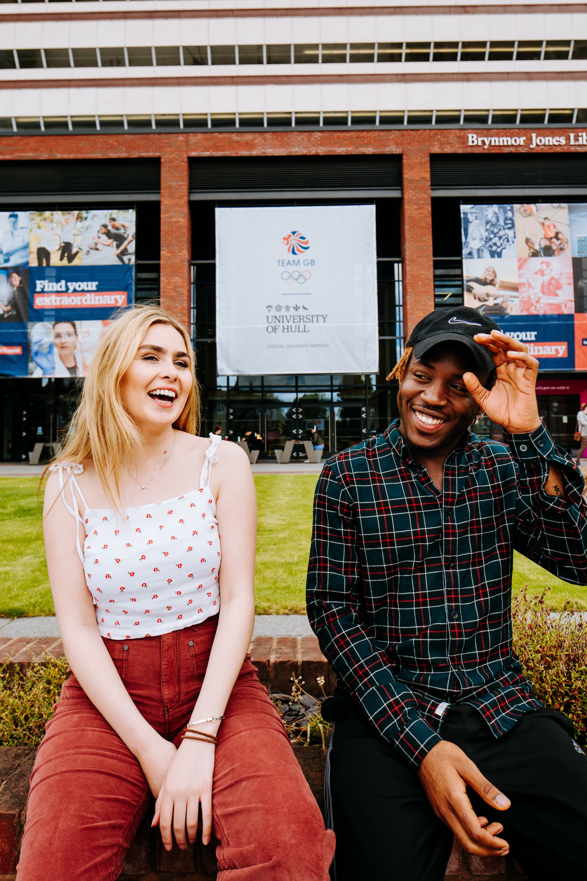 Two students sit outside the Brynmor Jones library
