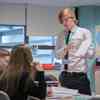 An Education Studies student stood at the front of a class talking to two school pupils during a placement 