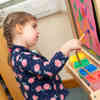 A child painting on an easel