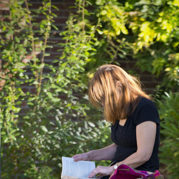 Female Reading on Plaza Curved Bench Exterior