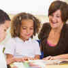 Schoolchildren and their teacher reading in classroom