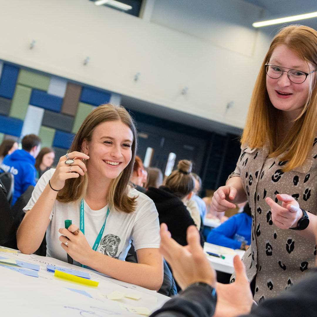 Secondary students sat around a table in a marketing workshop
