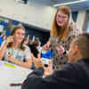 Secondary students sat around a table in a marketing workshop