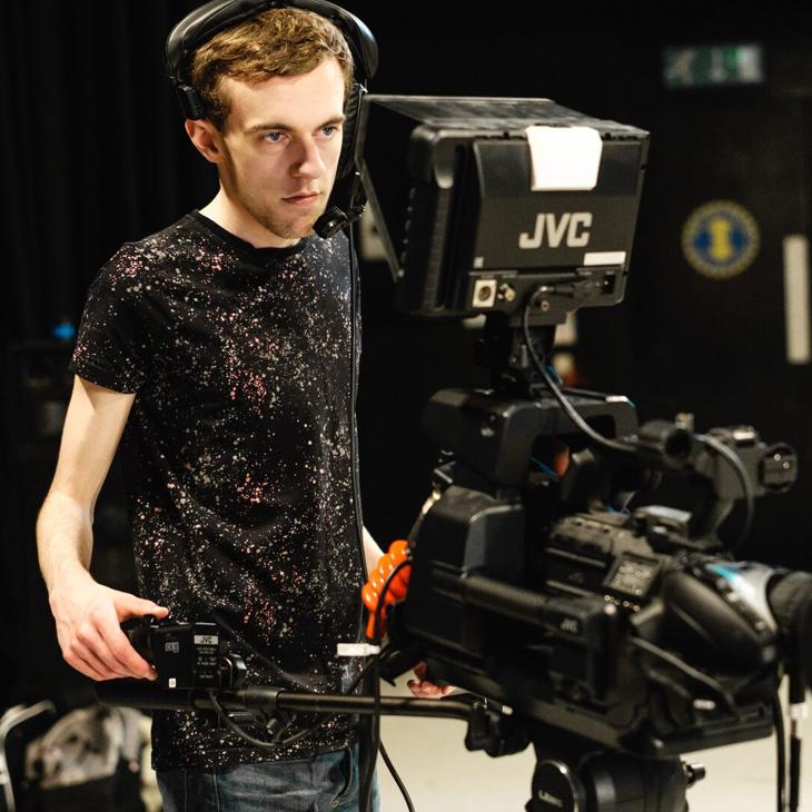 A student using a TV camera in a studio