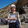 A female Geology student wears a hard hat and holds a clipboard on a Field Trip in Spain