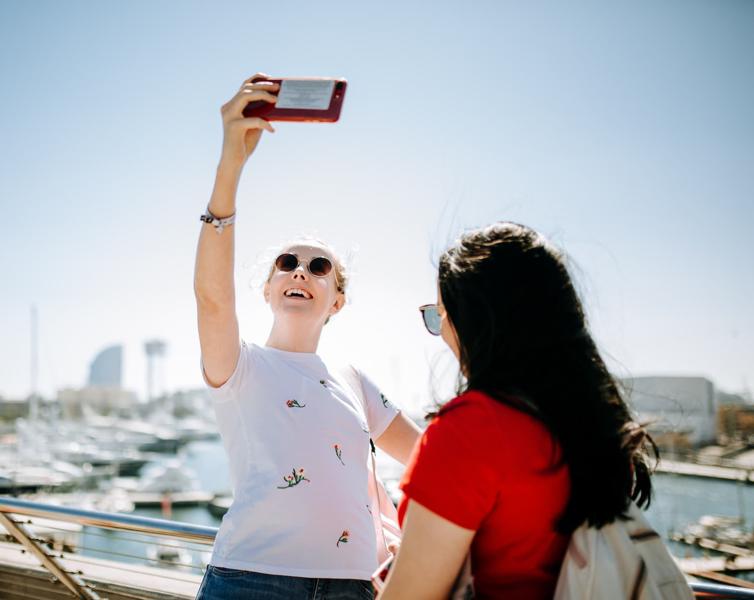 Millie North takes a photo at a marina in Barcelona during a Geography field trip