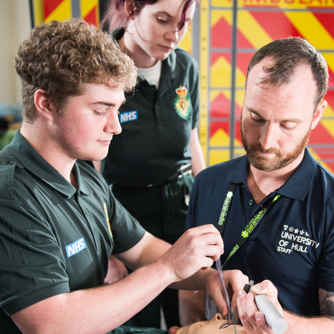 paramedic science students using dummy with tutor