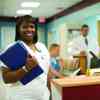a smiling nurse at a hospital reception desk