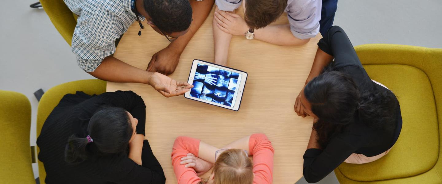 Aerial image of a group of students viewing X ray images on a tablet computer