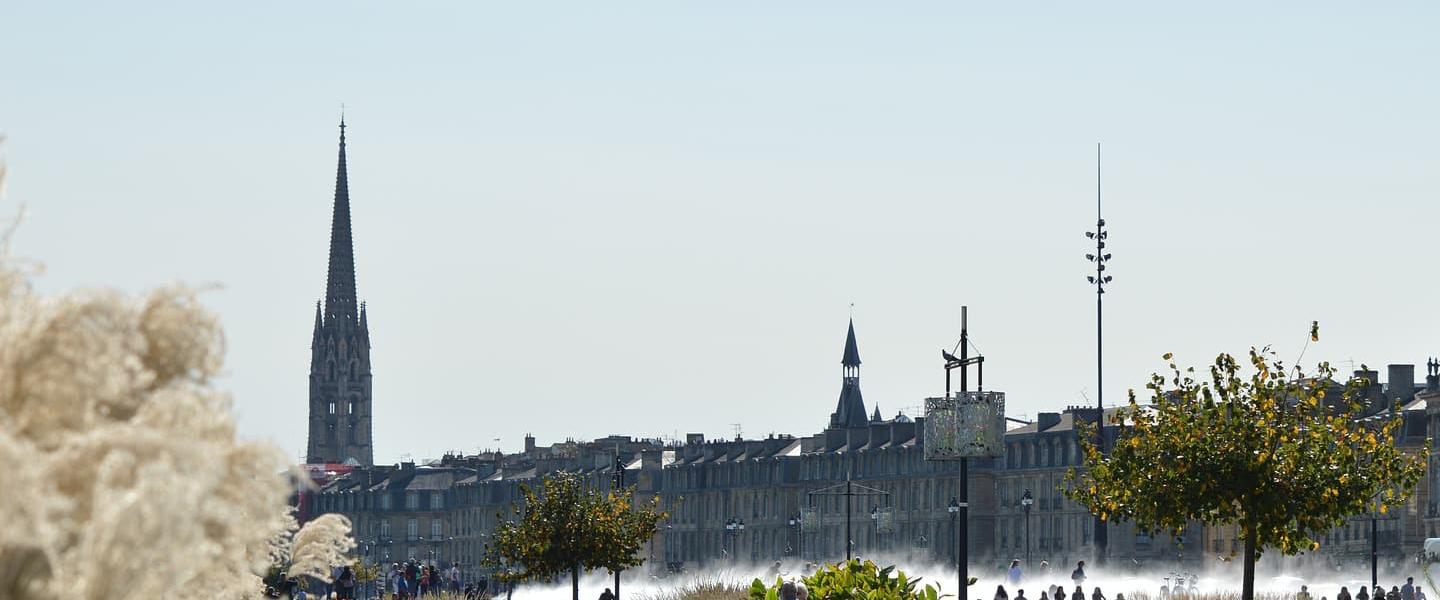 People relax on the grass in a park in Bordeaux on a sunny day