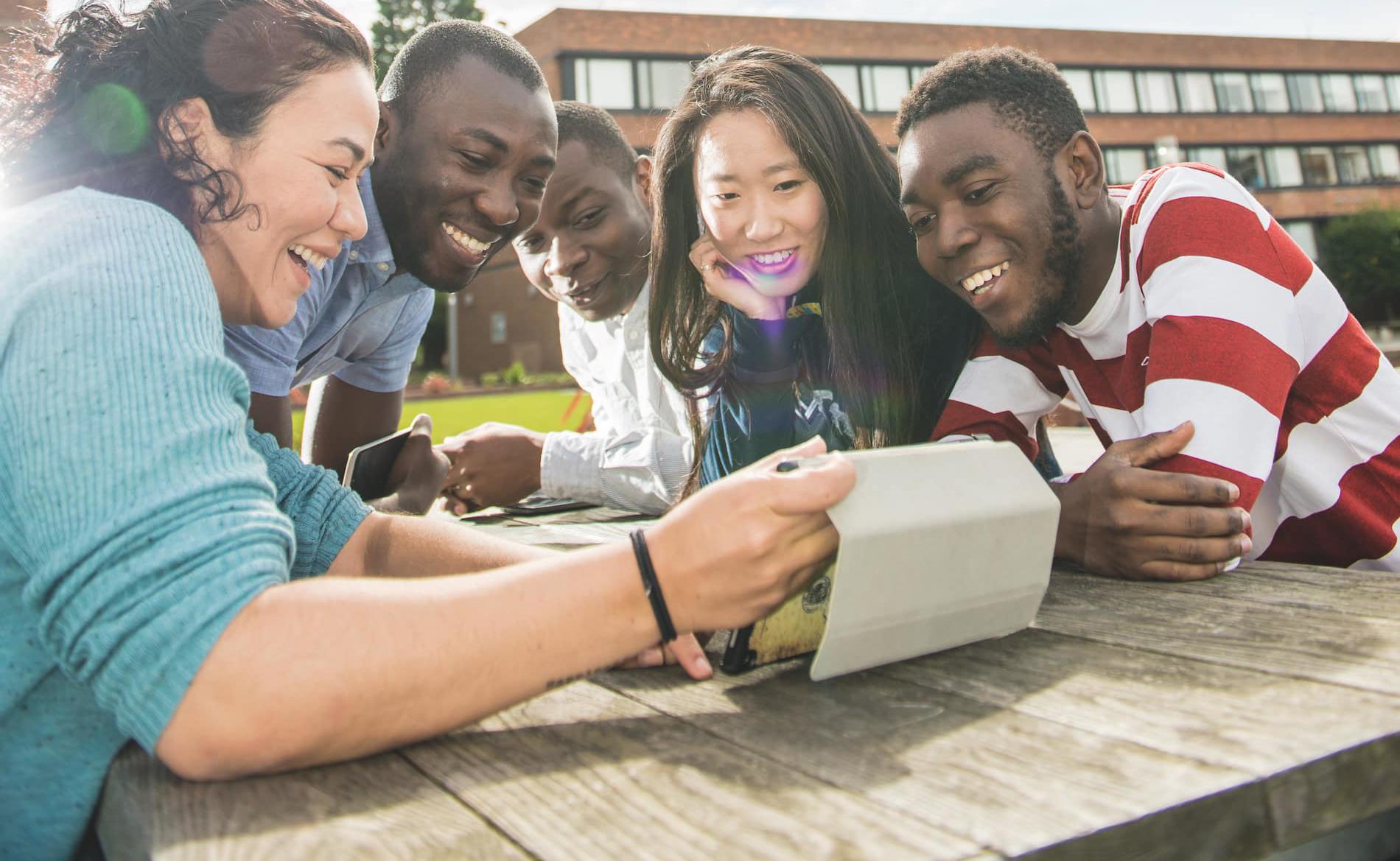 International students working on a tablet outside of the Brynmor Jones Library
