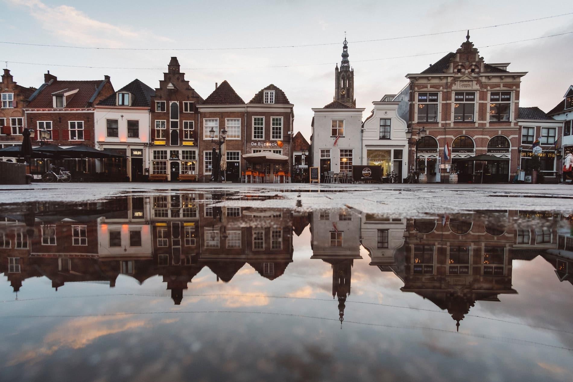 Buildings reflected in water on a street in the Netherlands