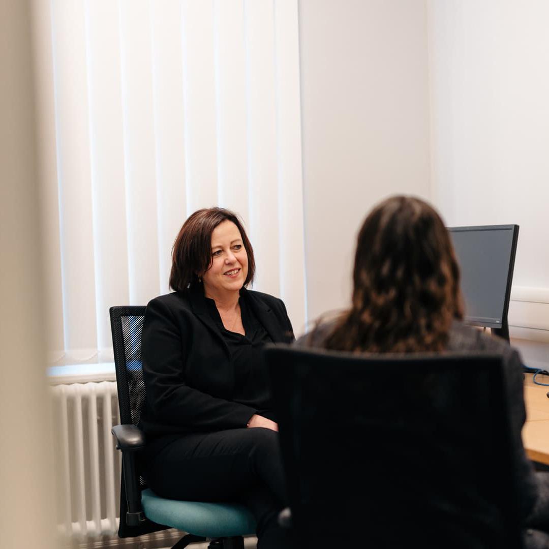 A lecturer and student sit in front of a computer monitor in the Legal Advice Centre