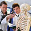Hull lecturer and student measuring an anatomical model of a human skeleton in the Medical Engineering Lab.