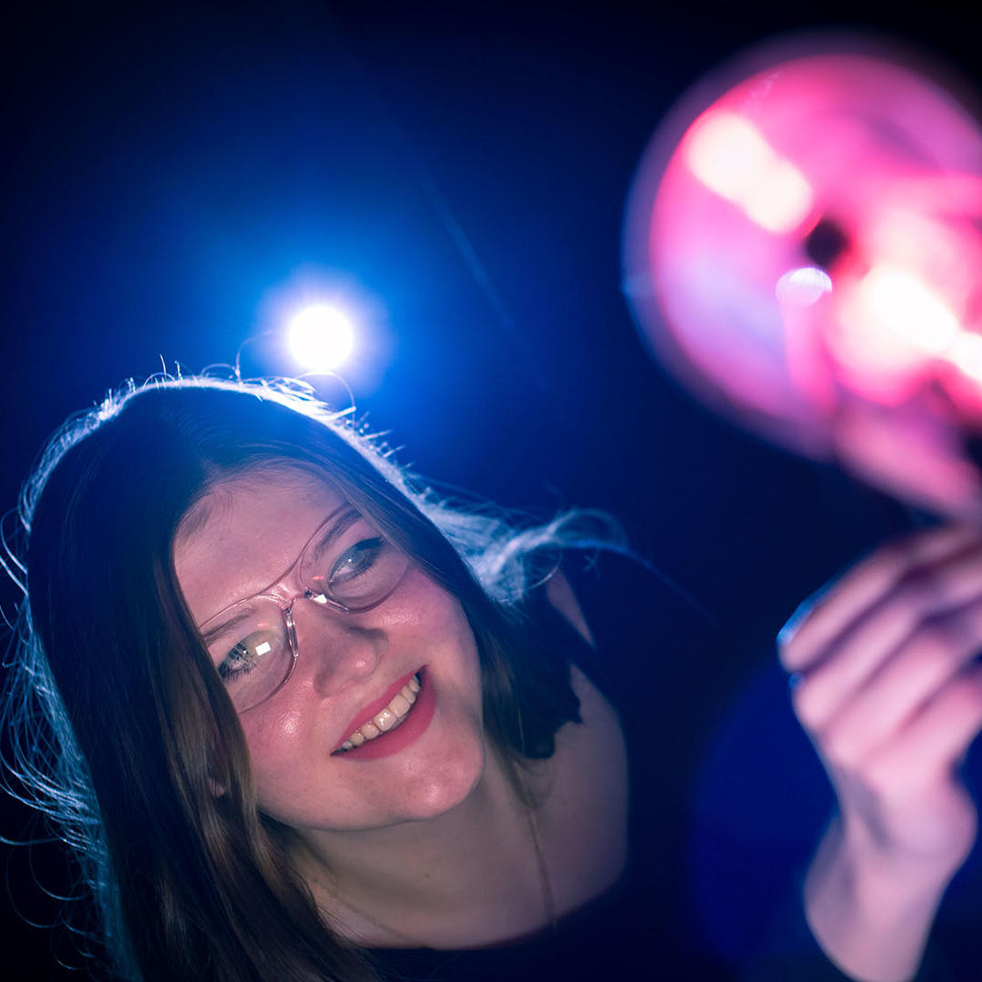 A student uses brightly coloured physics equipment