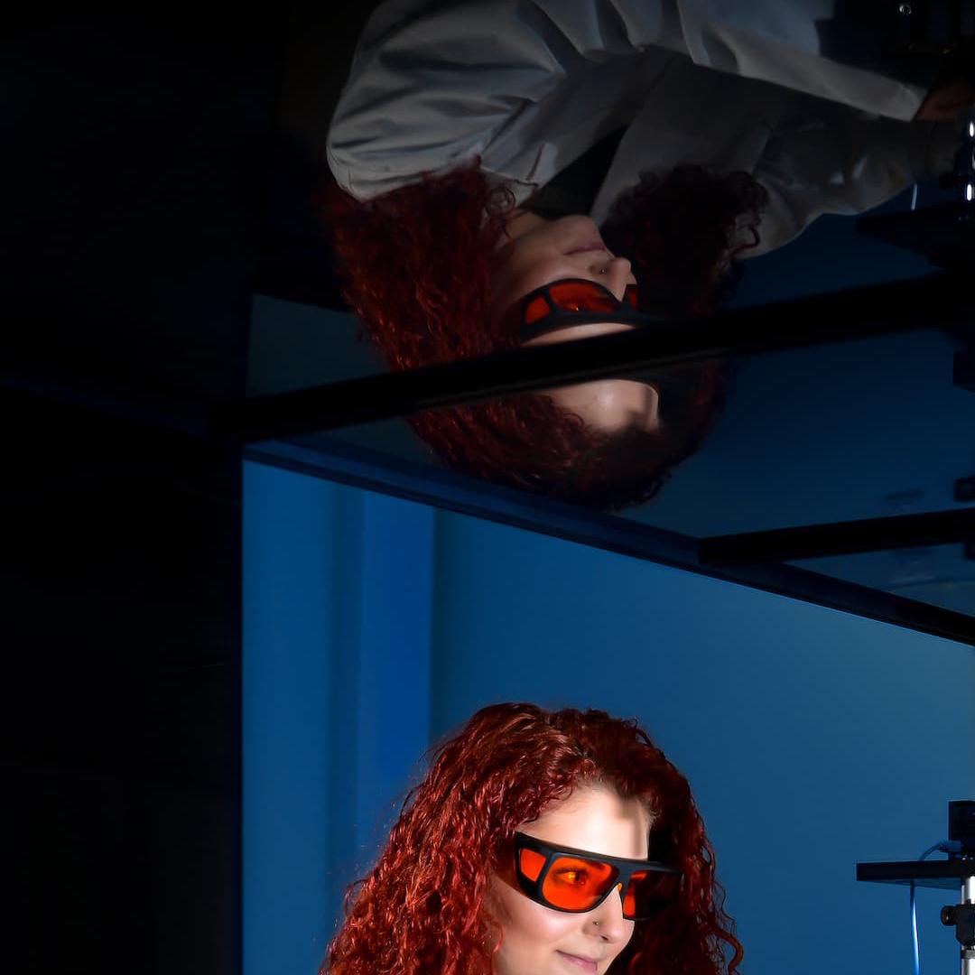 A student in a lab coat uses physics equipment in the George Grey Centre